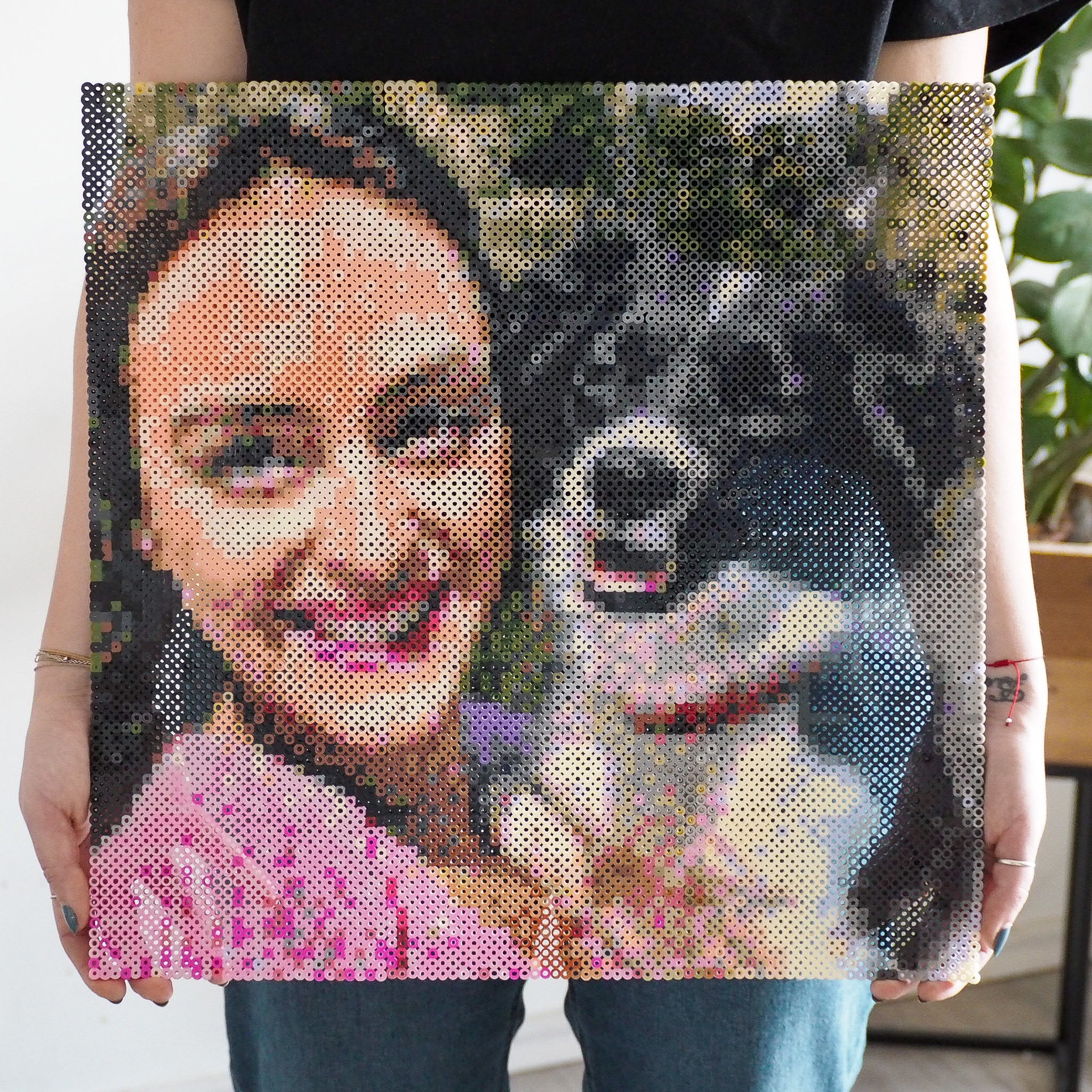 Person står med stor motiv af kvinde og hund lavet i perleplader